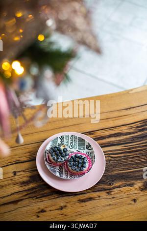 moscou, russie, 21.01.2019 deux délicieuses tartes aux myrtilles avec du sucre en poudre sur une assiette. Dessert pâtissier sucré sur une table en bois rustique. Nourriture de vacances pour c Banque D'Images