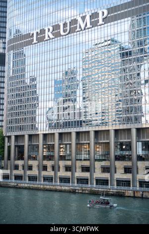 Un bateau de la Garde côtière AMÉRICAINE patrouille le fleuve Chicago, encadré par la Trump Tower et le Wrigley Building dans le centre-ville de Chicago Banque D'Images