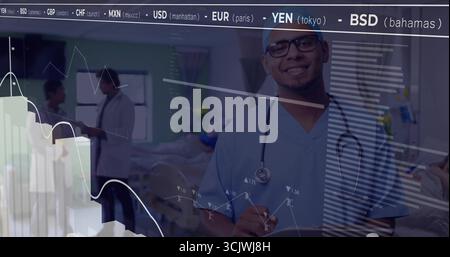 Médecin souriant dans des gommages bleus à l'hôpital tenant un stéthoscope avec superposition de tickers de stock Banque D'Images