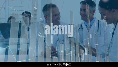 Examen de l'équipe médicale examinant les rapports à la table de conférence clinique avec des graphiques de stylos de tablette superposés Banque D'Images