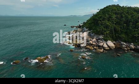 Vue aérienne de la côte accidentée où la forêt tropicale verdoyante rencontre la mer turquoise, créant un contraste saisissant de couleurs et de textures, Paraty, État de Rio de Janeiro, Brésil. Banque D'Images