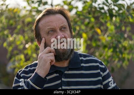 Portrait d'un homme âgé réfléchi ou surpris. Homme âgé barbu caucasien de nature. Affrontez les rêves masculins barbus de résoudre les problèmes, gros plan Banque D'Images
