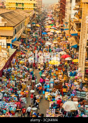 Accra, Ghana - 05 novembre 2022 : vue aérienne du marché de Makola, une tapisserie vibrante de l'humanité et du commerce, où des parapluies colorés et des étals serrés éclatent de vie sous le soleil africain. Banque D'Images