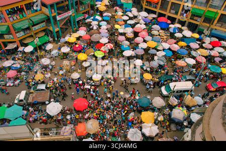 Accra, Ghana - 23 mars 2024 : vue aérienne de la scène animée du marché de Makola, où une tapisserie vibrante de parapluies colorés crée un effet kaléidoscopique sur le marché bondé. Banque D'Images
