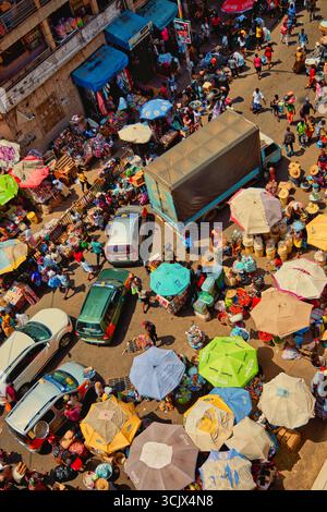 Accra, Ghana - 05 novembre 2022 : vue aérienne du marché animé de Makola, une tapisserie vibrante de parasols colorés, d'étals bondés et de véhicules naviguant sur la scène animée. Banque D'Images