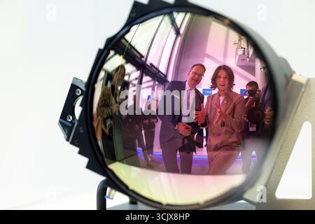 09 septembre 2025, Thuringe, Iéna/Göschwitz : Colette Boos-John (CDU), ministre de l'économie, de l'agriculture et des zones rurales, et Stefan Traeger, PDG de Jenoptik, regardent dans une exposition une lentille infrarouge utilisée pour la défense. Des projets d'investissement dans une installation de production de haute technologie pour l'optique à semi-conducteurs ont été présentés aujourd'hui à Jenoptik. Photo : Michael Reichel/dpa Banque D'Images