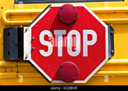 Gros plan d'un panneau d'arrêt d'autobus scolaire, avec le mot STOP, indiquant la sécurité routière. Banque D'Images