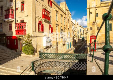 Rue avec des maisons historiques incroyables avec des balcons en bois colorés à la Valette, capitale de Malte, pont de Victoria Gate Banque D'Images