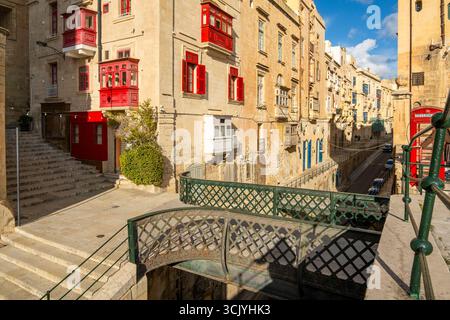 Rue avec des maisons historiques incroyables avec des balcons en bois colorés à la Valette, capitale de Malte, pont de Victoria Gate Banque D'Images