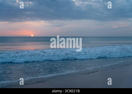 Lever de soleil sur l'océan à Nilaveli, Sri Lanka, les vagues roulent doucement Banque D'Images