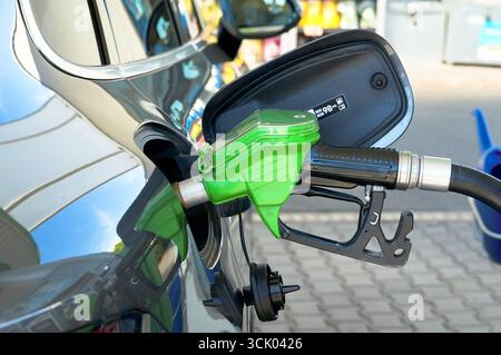 Gros plan d'une pompe à essence remplissant une voiture avec de l'essence. Banque D'Images
