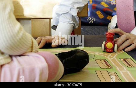 SOUS EMBARGO À 0001 MERCREDI 10 SEPTEMBRE photo du dossier datée du 11/11/04 d'un adulte jouant avec un enfant dans une crèche. Les ministres écossais pourraient changer la vie des familles en fournissant des services de garde d'enfants aux jeunes dès l'âge de neuf mois et en plafonnant les coûts pour les parents. Date d'émission : mercredi 10 septembre 2025. Banque D'Images