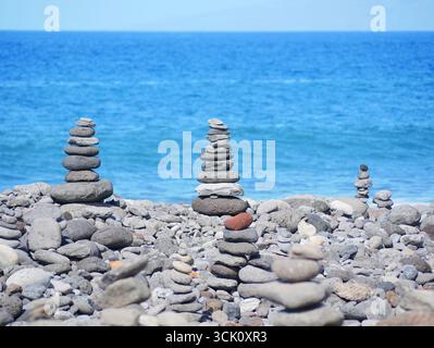 Cairns en pierre sur Rocky Beach avec Blue Sea en arrière-plan. Banque D'Images
