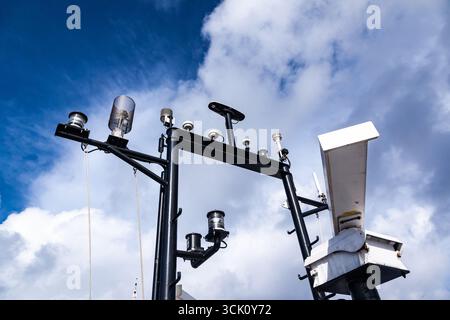 Mât de navire avec équipement de navigation, vue de dessous contre le ciel. Radar, feux de signalisation, antennes et équipements de navigation. Banque D'Images