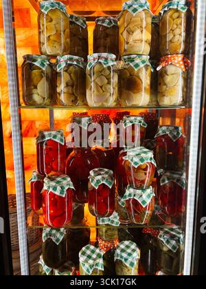 Affichage coloré de bocaux en verre avec des légumes marinés et des fruits sur une étagère Banque D'Images