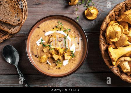 Soupe à la crème aux chanterelles et thym. Cuisine d'automne de saison - soupe de champignons chanterelles, vue de dessus. Banque D'Images