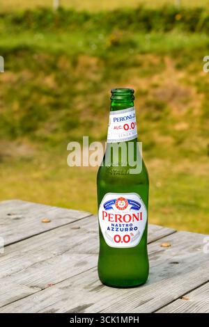 Fishguard, Pembrokeshire, pays de galles - 26 juillet 2025 : bouteille de bière sans alcool Peroni Nastro Azzurro sur une table extérieure dans le jardin d'un pub. Banque D'Images