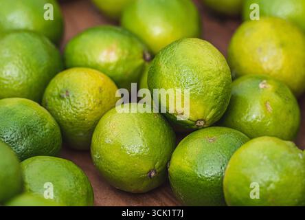 Citrons verts frais empilés ensemble dans un gros plan, mettant en valeur leur peau lisse et brillante et leurs couleurs éclatantes Banque D'Images