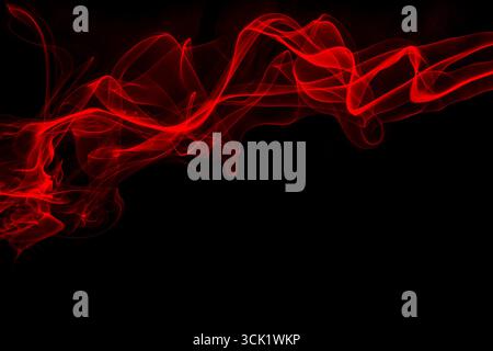 Mouvement abstrait de la vague de fumée rouge sur fond noir Banque D'Images