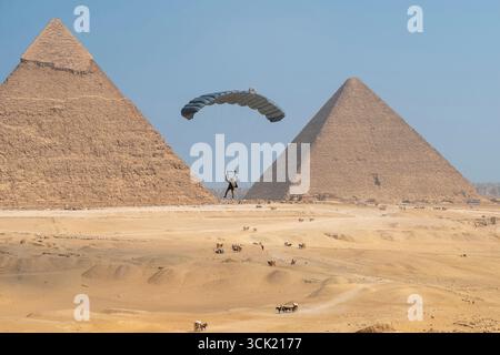 Gizeh, Égypte. 06 septembre 2025. Un soldat parachute au-dessus des touristes près des grandes pyramides de Gizeh lors de l’exercice militaire multinational Bright Star 25, le 6 septembre 2025 à Gizeh, en Égypte. Soldats représentant les États-Unis Égypte, Royaume-Uni, Italie, Grèce, Chypre, Arabie saoudite, Inde, Jordanie, Kirghizistan, Qatar, L'Afrique du Sud et le Yémen ont participé à l'exercice. Crédit : SRA Erin Dunkleberger/U.S. Air Force photo/Alamy Live News Banque D'Images