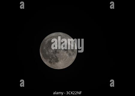 Une photographie haute résolution de la pleine lune, mettant en valeur les détails riches de sa surface lunaire. L'image capture parfaitement les ombres d'innombrables Banque D'Images