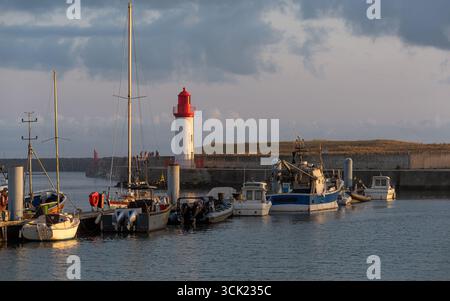 Port de pêche paisible de la Cotinière (sur l'île d'Oléron) avec son magnifique phare rouge et blanc au coucher du soleil. Banque D'Images