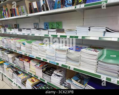Cahiers et livres colorés sur les étagères du magasin dans l'allée de la papeterie. Banque D'Images