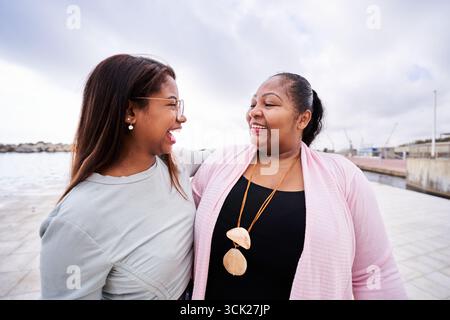 Deux femmes heureuses partageant un rire au bord de la mer Banque D'Images