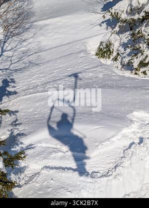 Ombre d'un snowboarder sur un télésiège jeté sur la neige blanche fraîche en hiver Banque D'Images