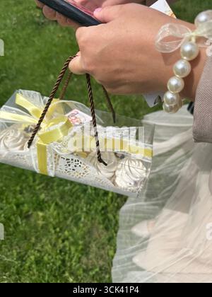 Femme tenant une guimauve dans une boîte cadeau dans sa main. Gros plan. Banque D'Images