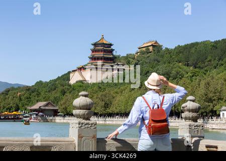 Une voyageuse se relaxant et profitant de la vue sur la nature depuis un ancien temple chinois, une attraction touristique à Pékin, en Chine. Palais d'été touri Banque D'Images