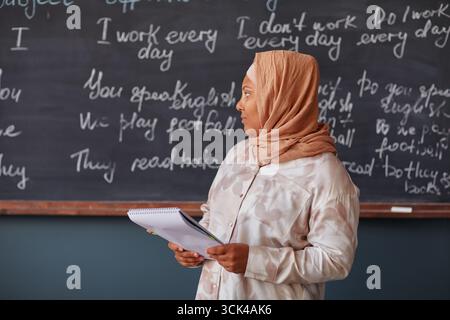 Femme musulmane d'âge moyen enseignant des leçons d'anglais à la classe de l'école de langue Banque D'Images