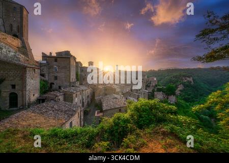 Coucher de soleil spectaculaire sur l'ancien village médiéval de Sorano en Maremme, Toscane. Bâtiments historiques en pierre et forteresse illuminés par la lumière dorée à d. Banque D'Images