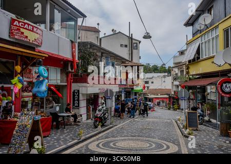 Les gens marchent et font du shopping le long d'une rue pavée bordée de cafés et d'entreprises locales dans le centre-ville de Termal, Yalova, Türkiye. Termal, Yalova, T. Banque D'Images