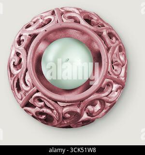 Bougeoir décoratif aux motifs complexes entourant une bougie chauffe-plat. Banque D'Images