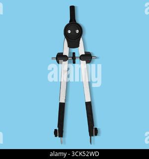 Boussole noire et argentée utilisée pour dessiner des cercles et mesurer des distances dans les dessins techniques. Banque D'Images