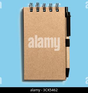 Un bloc-notes simple avec reliure en spirale et un stylo attaché, idéal pour prendre des notes ou réfléchir à des idées. Banque D'Images
