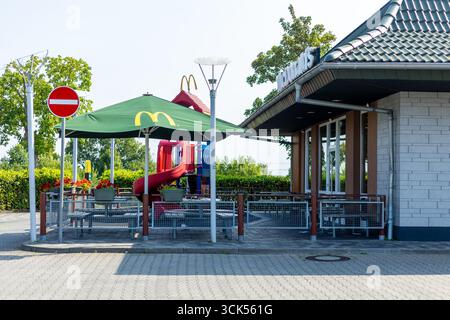 Kerpen, Allemagne - 9 août 2025 : extérieur du restaurant McDonalds avec terrasse et parasols Banque D'Images