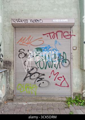 Graffiti peint sur porte de volet métallique fermée dans une rue urbaine Banque D'Images