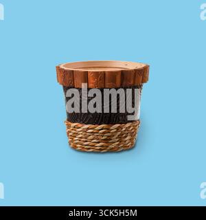 Pot à plantes décoratif avec une surface noire texturée et un rebord en bois, conçu pour exposer des plantes. Banque D'Images