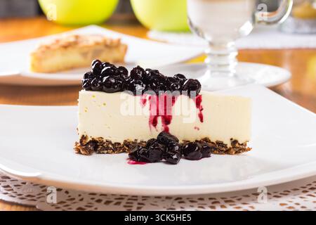 Tranche de cheesecake décorée de confiture de myrtilles en gros plan Banque D'Images