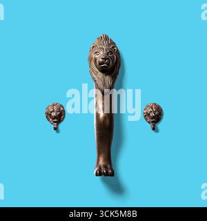 Une poignée de porte décorative en forme de tête de lion, accompagnée de deux plus petits frappeurs de tête de lion, mettant en valeur un design complexe. Banque D'Images