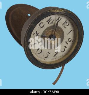 Cette image montre une horloge antique avec un visage rond, montrant les chiffres et les aiguilles, monté sur une base en bois. Banque D'Images