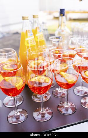 Plusieurs verres à cocktail avec une boisson de couleur orange et des tranches d'orange, disposés sur une table à l'extérieur, lac de Constance, Allemagne Banque D'Images