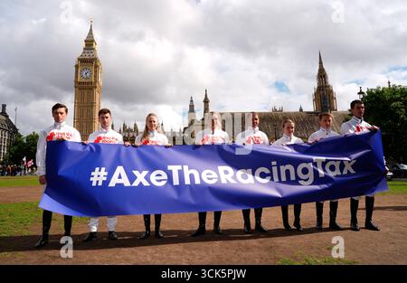 Jockeys Kieran Shoemark, Oisin Murphy, Saffie Osborne, Lily Pinchin, Richard Johnson, Hollie Doyle, Tom Marquand et Paul O'Brien (de gauche à droite) brandissent une bannière axe the Racing Tax à Parliament Square, Westminster, Londres. Les courses britanniques vont s’arrêter aujourd’hui alors que le sport cherche à démontrer son opposition aux propositions de modification de la taxe sur les Paris. Date de la photo : mercredi 10 septembre 2025. Banque D'Images