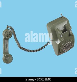 Un téléphone rotatif vert vintage avec un cordon enroulé et un récepteur, représentant la technologie de communication classique. Banque D'Images
