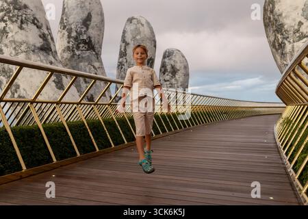 Famille avec enfants, visitant le Pont d'Or avec de grandes mains dorées le tenant à Da Nang, Ba Ha Hills destination de voyage, Vietnam Summertime sur su Banque D'Images