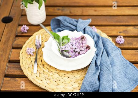 Décor printanier avec fleurs de lilas sur une table extérieure Banque D'Images