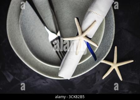Table d'été blanc avec l'étoile de mer sur fond de béton with copy space Banque D'Images