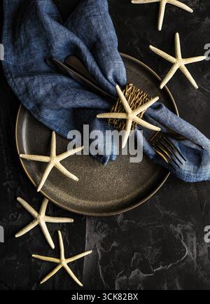 Table d'été blanc avec l'étoile de mer sur fond de béton with copy space Banque D'Images